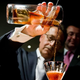 man pouring cocktail into glass